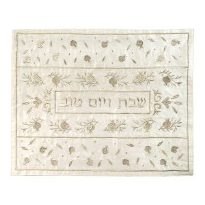כיסוי חלה לשבת משולב בבדים ורקמות שונות בגווני זהב על רקע שמנת, עם עיטורי רימונים וכיתוב שבת ויום טוב