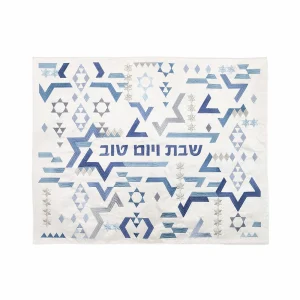 כיסוי חלה לשבת משולב בבדים ורקמות שונות בגווני כחול, תכלת וכסף על רקע שמנת, עם עיטורי צורות גיאומטריות ומגיני דוד וכיתוב שבת ויום טוב