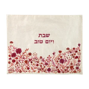 כיסוי חלה לשבת משולב בבדים ורקמות שונות בגווני ורוד, בורדו ואדום על רקע שמנת, עם עיטורי פרחים וכיתוב שבת ויום טוב