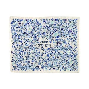 כיסוי חלה לשבת משולב בבדים ורקמות שונות בגווני כחול ותכלת על רקע שמנת, עם עיטורי ציפורים ופרחים וכיתוב שבת ויום טוב